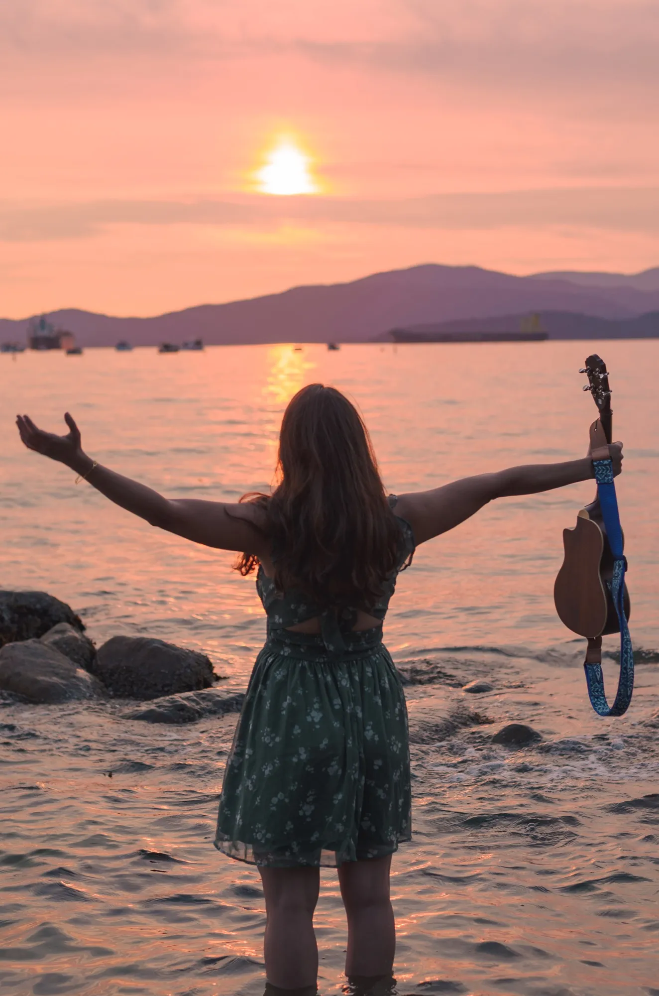 Ani with arms wide open toward the setting sun, ukulele in hand