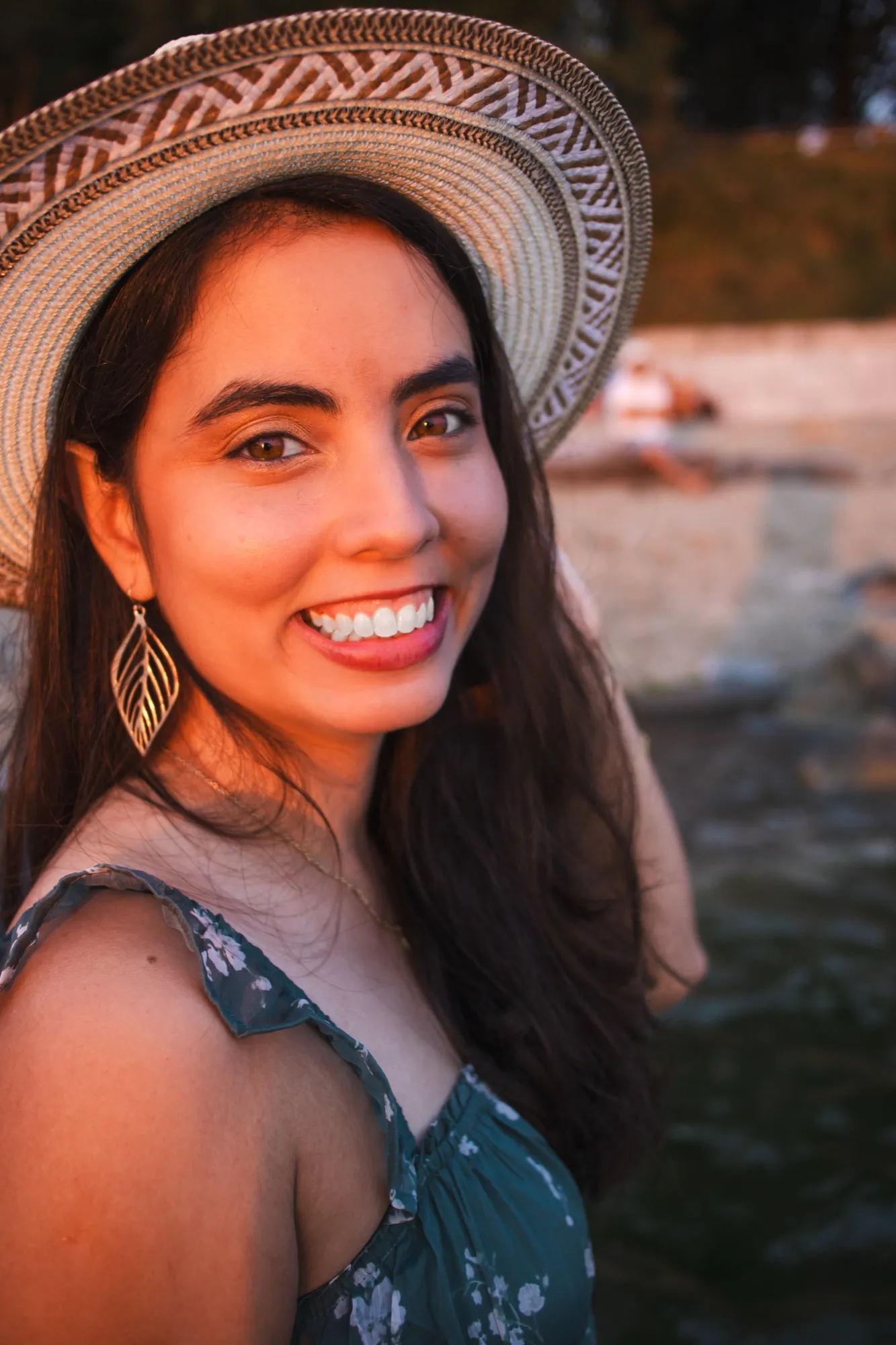 Close-up portrait of Ani smiling in a patterned hat